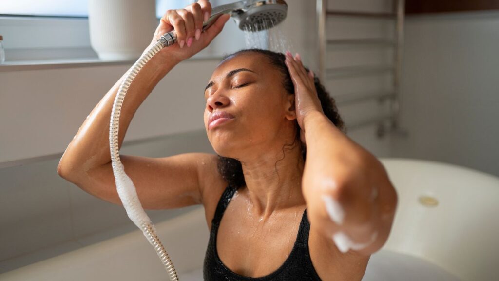 A woman is showering her hair