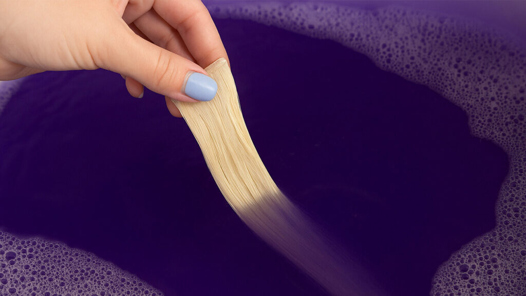Dipping Genius weft into water mixed with purple shampoo